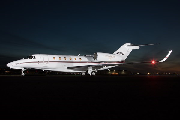 White jet on runway - night view